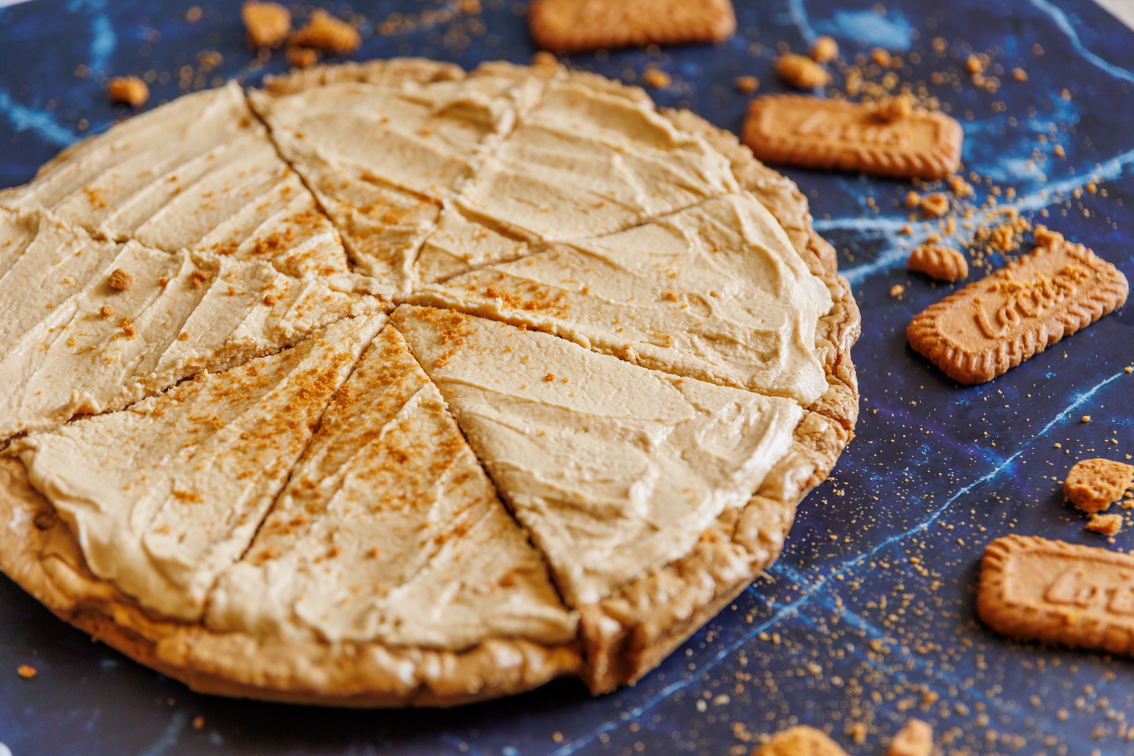 1991 cookie pizza sliced with cookie butter and cheesecake flavor with Lotus Biscoff crumbles 