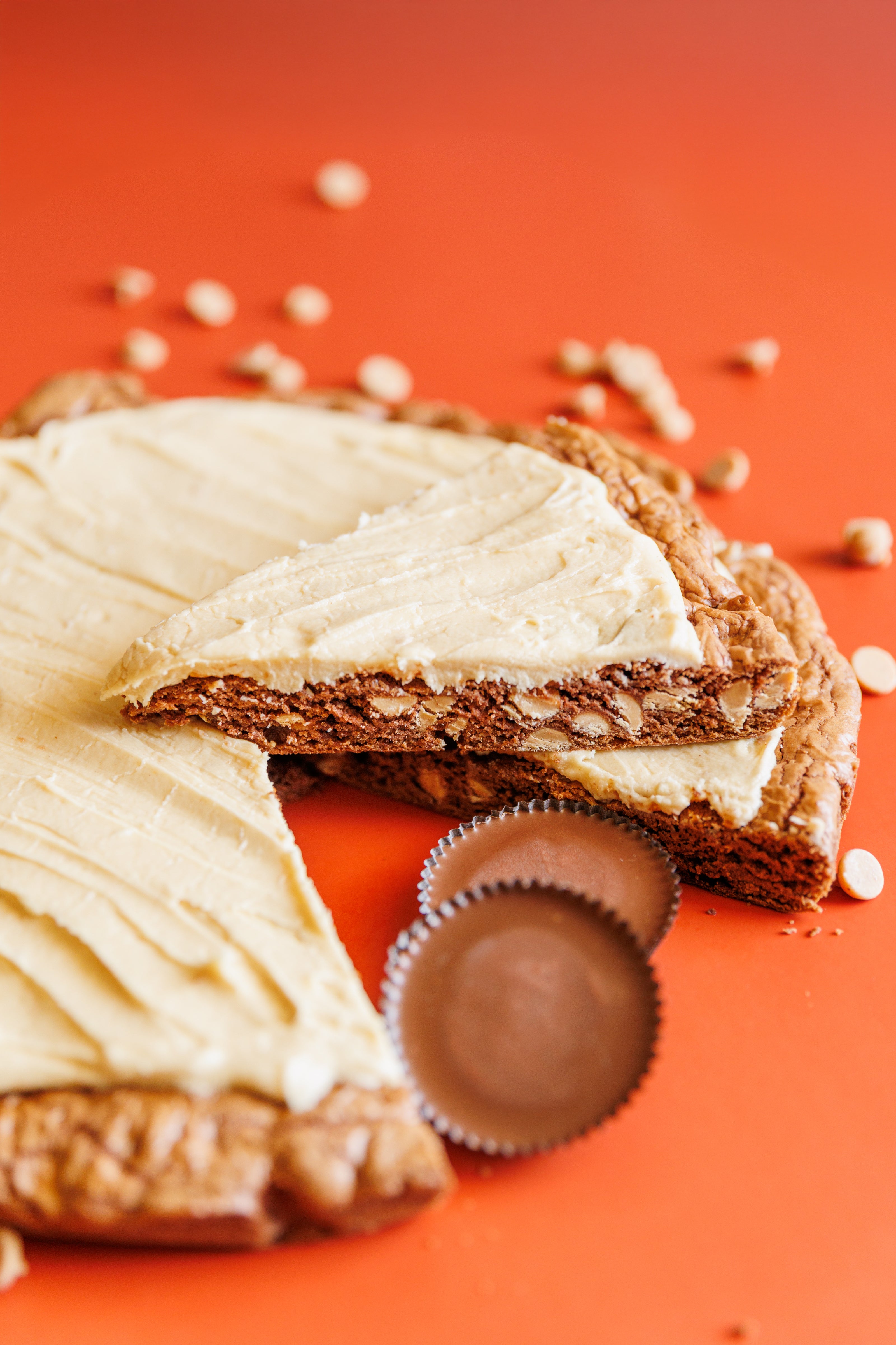 PB Sabotage chocolate and peanut butter cookie pizza with peanut butter chips and reese's cups with slice cut out